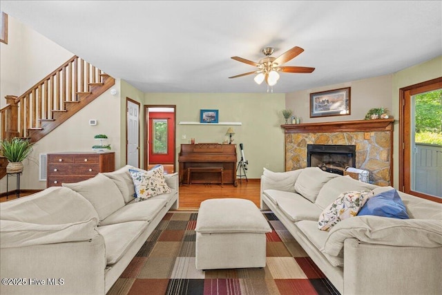 476 Paige Riddick Rd, Gates, NC 27937 - living room with ceiling fan, a stone fireplace, stairs, and wood finished floors