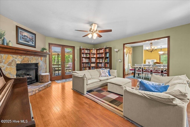 476 Paige Riddick Rd, Gates, NC 27937 - living area with hardwood / wood-style flooring, a fireplace, a chandelier, and ceiling fan