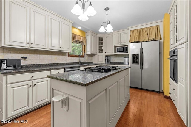 476 Paige Riddick Rd, Gates, NC 27937 - kitchen with black appliances, a chandelier, a sink, a kitchen island, and backsplash
