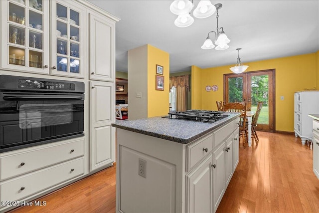 476 Paige Riddick Rd, Gates, NC 27937 - kitchen with black appliances, a chandelier, a kitchen island, light wood finished floors, and white cabinetry