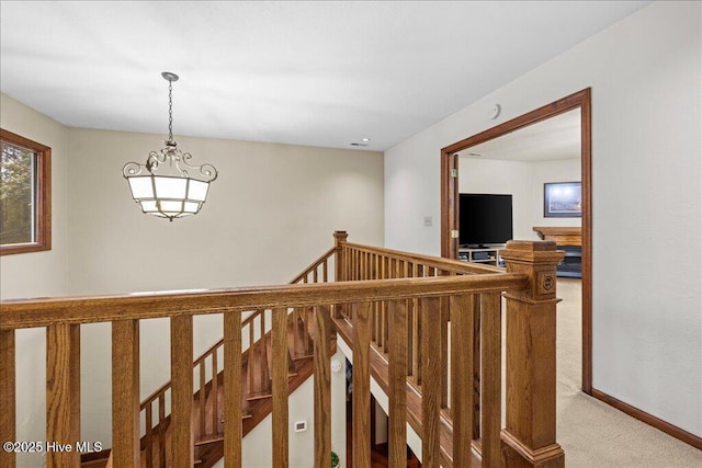 476 Paige Riddick Rd, Gates, NC 27937 - hallway featuring light carpet, an upstairs landing, a chandelier, and baseboards