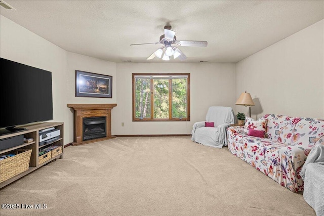 476 Paige Riddick Rd, Gates, NC 27937 - living room with carpet flooring, ceiling fan, a fireplace with raised hearth, baseboards, and a textured ceiling