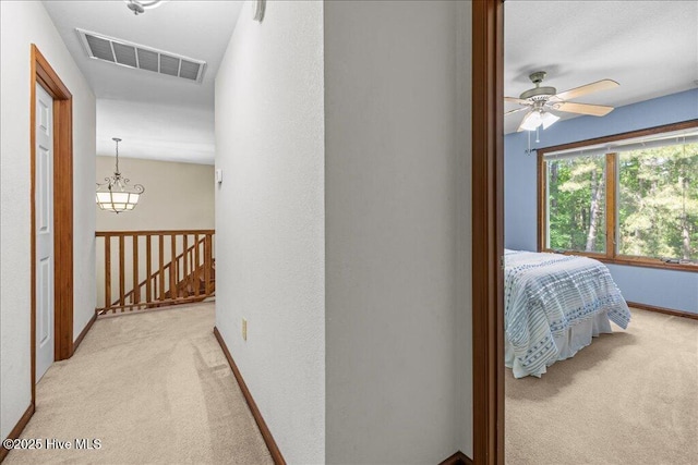 476 Paige Riddick Rd, Gates, NC 27937 - hallway with light carpet, an upstairs landing, a chandelier, and baseboards
