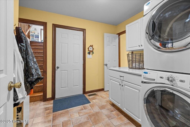 476 Paige Riddick Rd, Gates, NC 27937 - washroom featuring cabinet space, stacked washer / dryer, baseboards, and light stone finish floors
