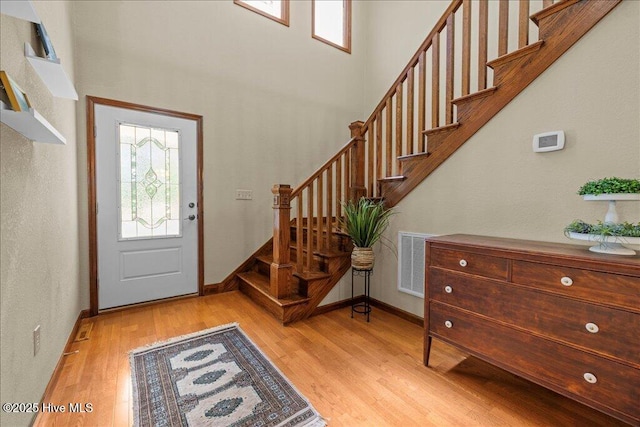 476 Paige Riddick Rd, Gates, NC 27937 - foyer with plenty of natural light, light wood-style flooring, stairway, a towering ceiling, and baseboards