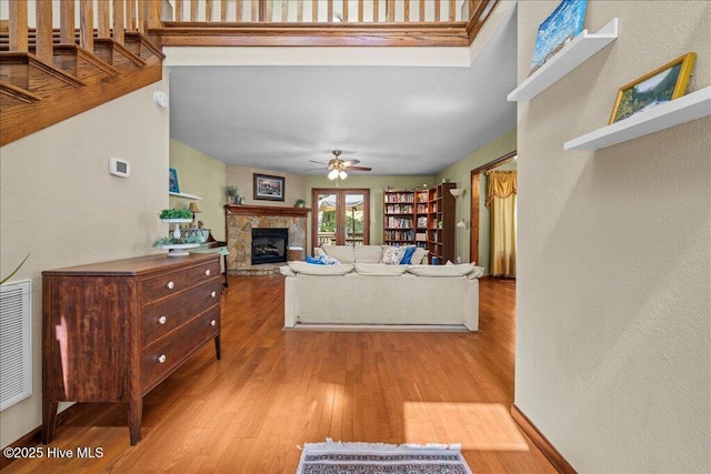 476 Paige Riddick Rd, Gates, NC 27937 - living area with a stone fireplace, a ceiling fan, wood finished floors, and a textured wall
