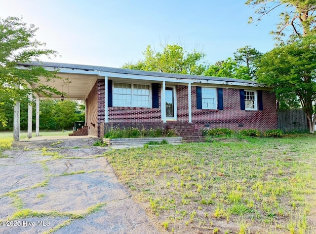 ranch-style home featuring brick siding, asphalt driveway, an attached carport, and fence