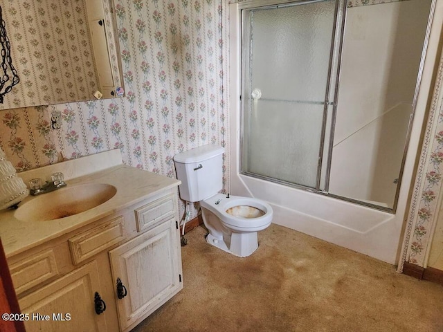 bathroom with toilet, wallpapered walls, enclosed tub / shower combo, vanity, and baseboards