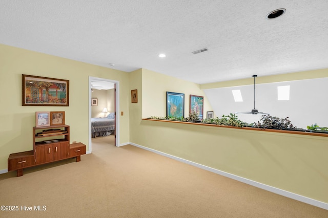 hall with carpet, a textured ceiling, baseboards, and recessed lighting