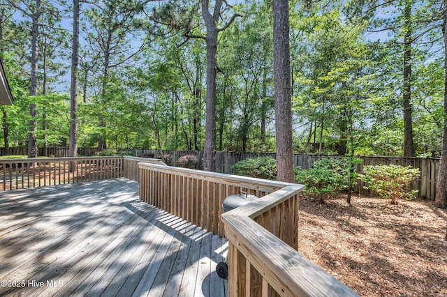 deck with a fenced backyard and view of scattered trees