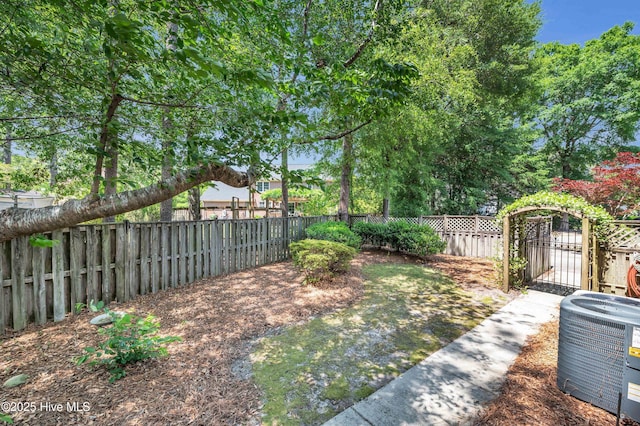fenced backyard featuring cooling unit and a gate
