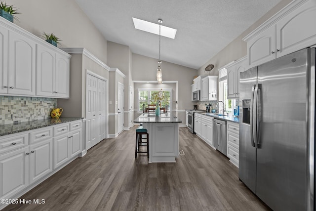 306 Channel Run Dr, New Bern, NC 28562 - kitchen featuring stainless steel appliances, a sink, white cabinets, a textured ceiling, and high vaulted ceiling