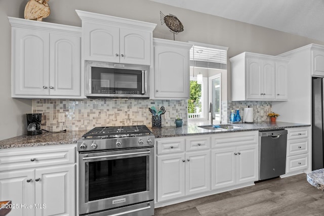 306 Channel Run Dr, New Bern, NC 28562 - kitchen with stainless steel appliances, a sink, dark stone counters, wood finished floors, and white cabinets