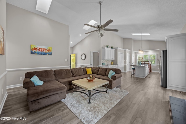 306 Channel Run Dr, New Bern, NC 28562 - living room featuring a skylight, high vaulted ceiling, baseboards, wood finished floors, and a ceiling fan