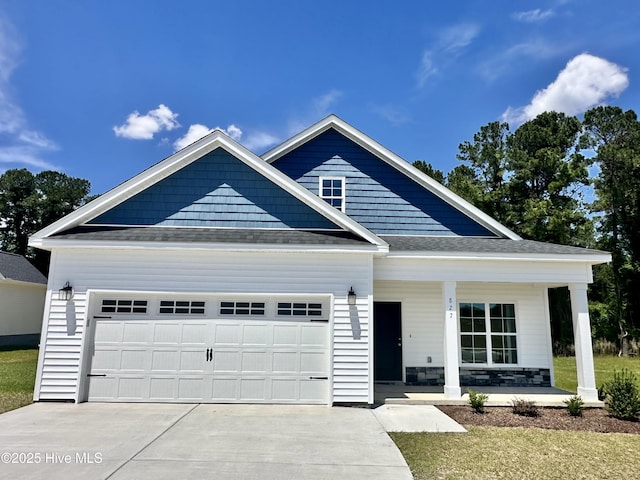 view of front of property featuring a porch, a garage, concrete driveway, and a shingled roof