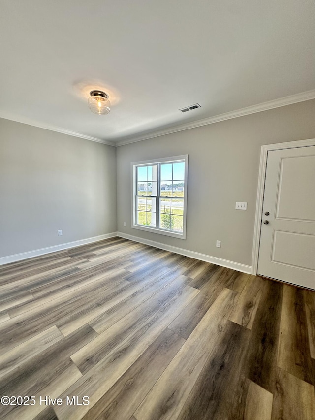 unfurnished room featuring ornamental molding, dark wood-style flooring, and baseboards