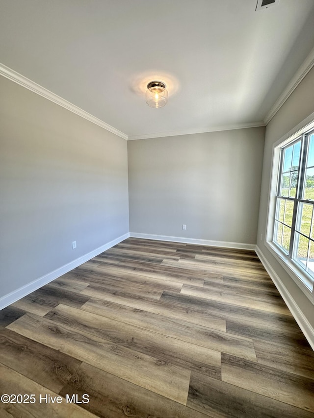 empty room with ornamental molding, baseboards, and dark wood-type flooring