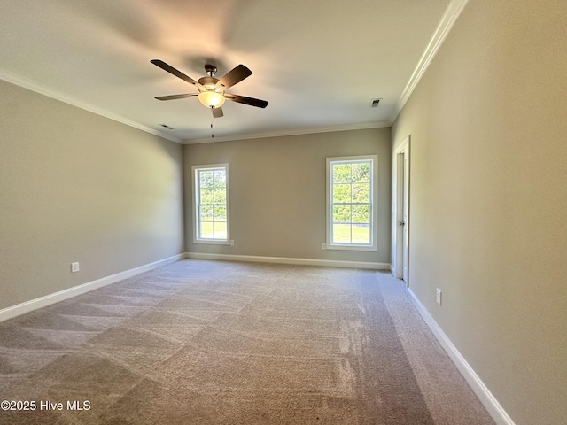 empty room featuring carpet flooring, crown molding, ceiling fan, and baseboards