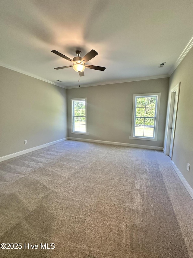 spare room featuring ornamental molding, carpet flooring, baseboards, and a ceiling fan