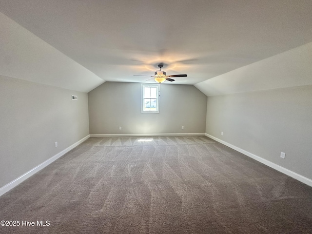 additional living space with carpet floors, vaulted ceiling, a ceiling fan, and baseboards