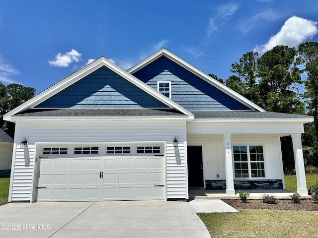 view of front of house with a porch, driveway, a garage, and a shingled roof