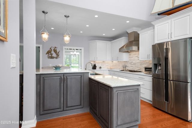 555 Dawson Creek Dr, Arapahoe, NC 28510 - kitchen with appliances with stainless steel finishes, a sink, wall chimney exhaust hood, light wood finished floors, and recessed lighting