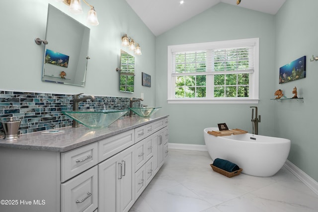 555 Dawson Creek Dr, Arapahoe, NC 28510 - full bath with marble look tile flooring, backsplash, double vanity, baseboards, and lofted ceiling
