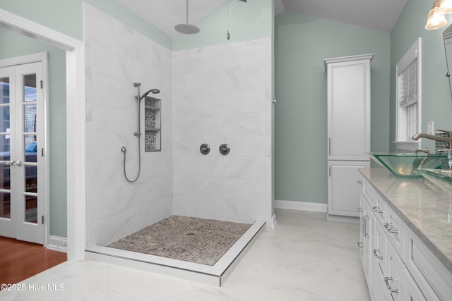 555 Dawson Creek Dr, Arapahoe, NC 28510 - bathroom featuring vaulted ceiling, a tile shower, vanity, marble look tile flooring, and french doors