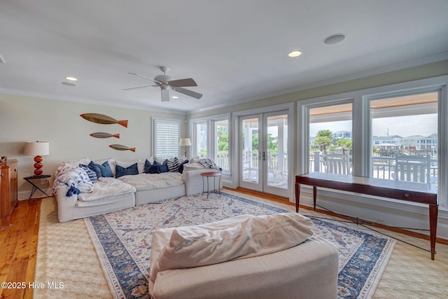 living area with french doors, ceiling fan, crown molding, recessed lighting, and light wood-style flooring