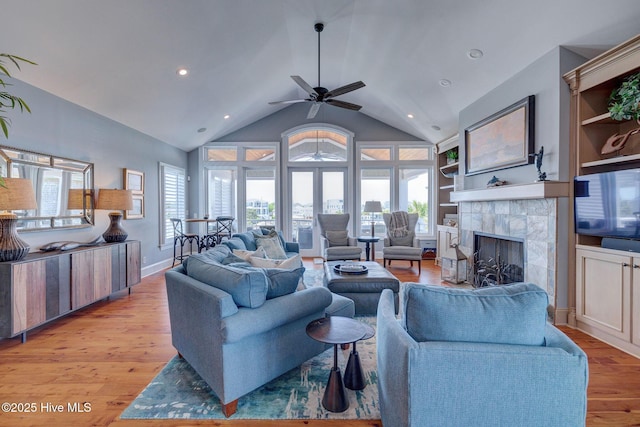 living room with light wood-style floors, a fireplace, ceiling fan, recessed lighting, and high vaulted ceiling