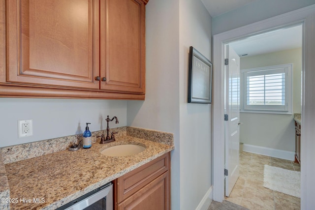 bathroom featuring vanity, baseboards, and wine cooler