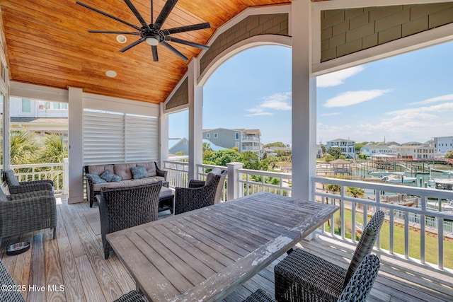 wooden deck with a ceiling fan, an outdoor living space, outdoor dining space, and a residential view