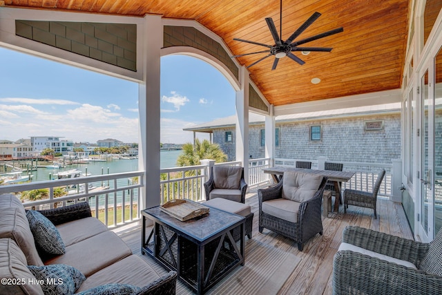 wooden deck featuring a water view, ceiling fan, an outdoor hangout area, and outdoor dining space