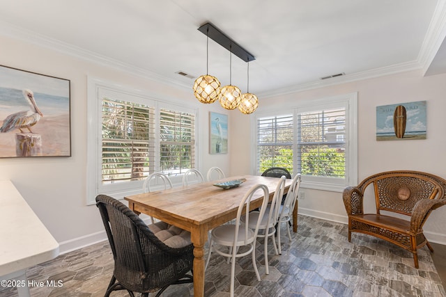 dining room with stone finish flooring, ornamental molding, and baseboards