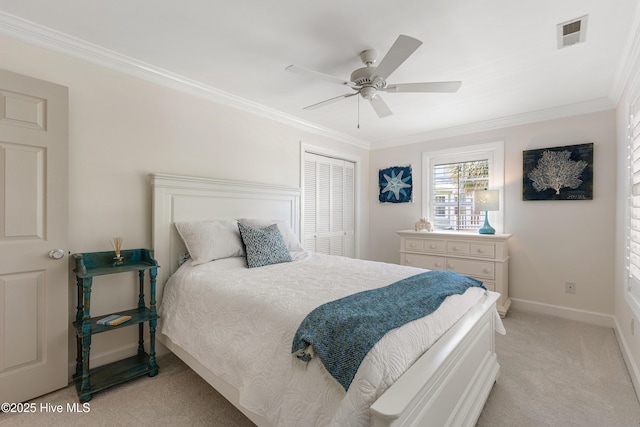 bedroom with light colored carpet, crown molding, a closet, a ceiling fan, and baseboards