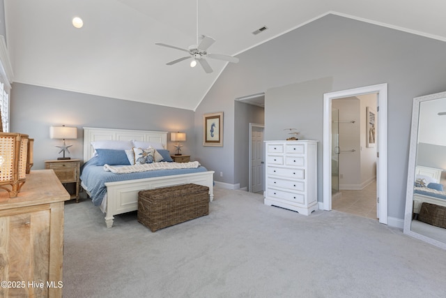 bedroom featuring light colored carpet, high vaulted ceiling, baseboards, connected bathroom, and ceiling fan