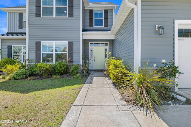 view of exterior entry with a yard
