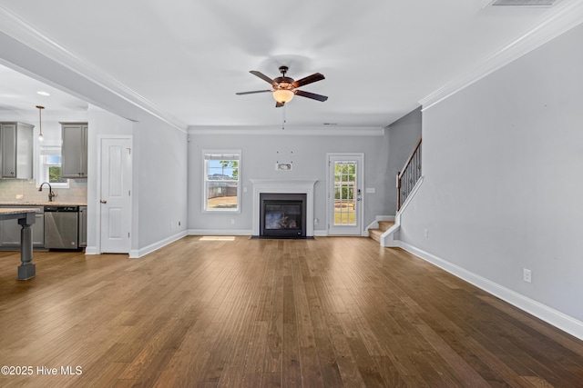 unfurnished living room with a fireplace with flush hearth, ceiling fan, stairway, wood finished floors, and baseboards