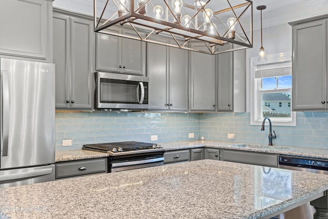 kitchen featuring stainless steel appliances, gray cabinets, a sink, decorative backsplash, and light stone counters