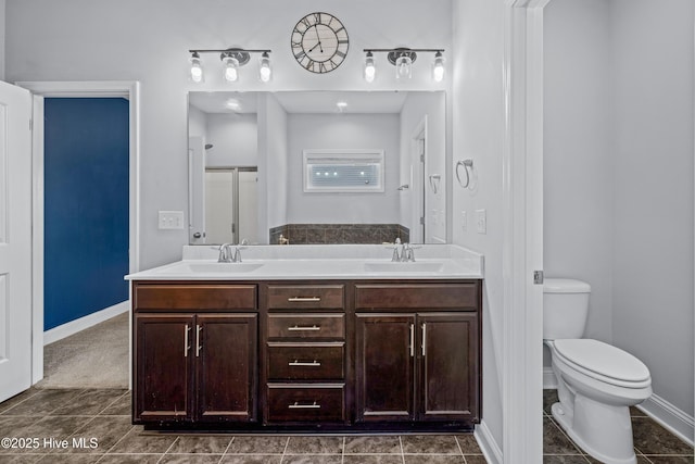 full bath featuring toilet, double vanity, baseboards, and tile patterned flooring
