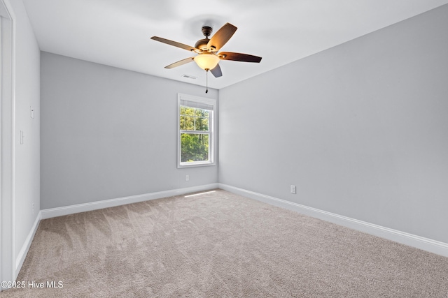 carpeted empty room featuring baseboards and ceiling fan