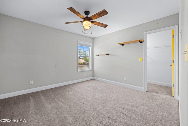 carpeted empty room with ceiling fan and baseboards