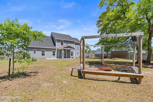 back of house with a pergola and roof with shingles