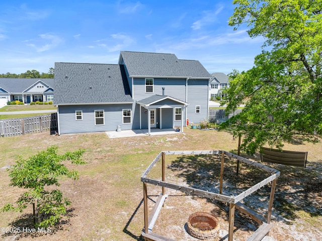 back of house with a patio, a fire pit, a shingled roof, and a vegetable garden
