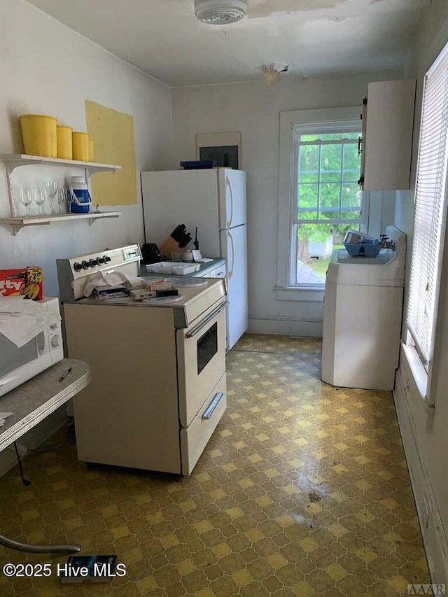 kitchen featuring white appliances, washer / dryer, and open shelves