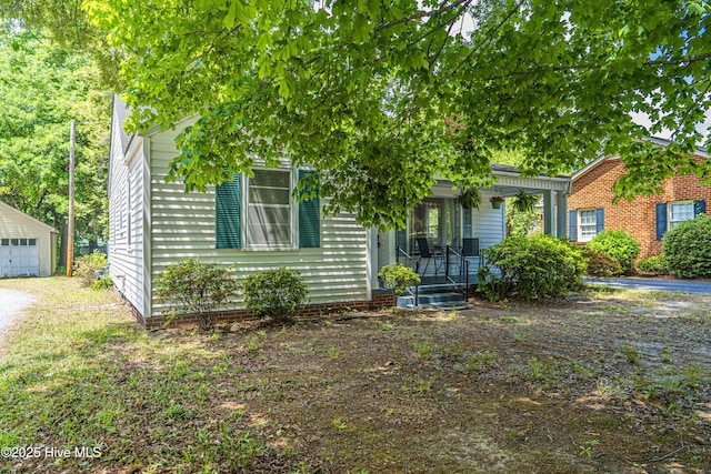 513 Atkinson St, Laurinburg, NC 28352 - view of front of house with covered porch, an outdoor structure, and a garage