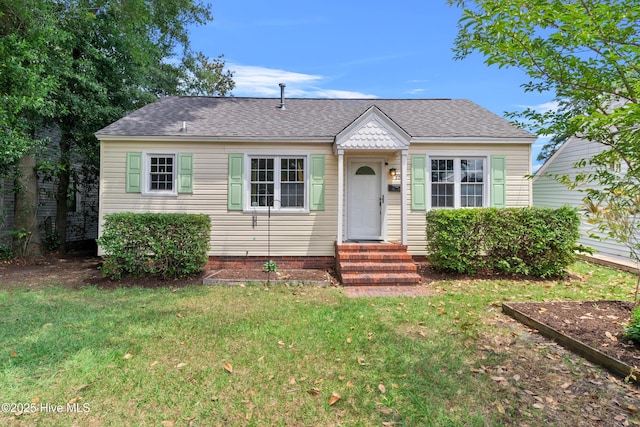 bungalow with a front yard, roof with shingles, and entry steps