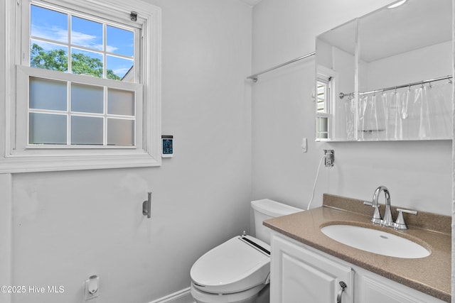 full bathroom with healthy amount of natural light, toilet, vanity, and curtained shower