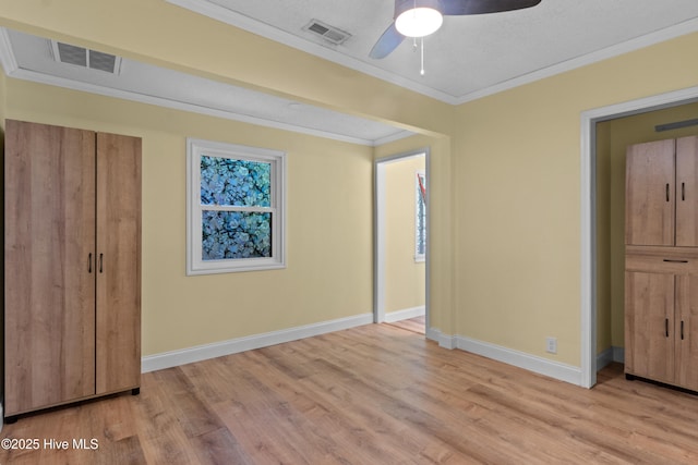 unfurnished bedroom featuring light wood finished floors, baseboards, and crown molding