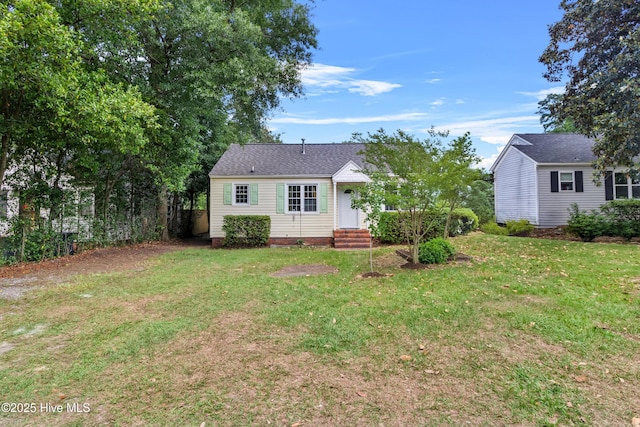 rear view of house with a lawn and a shingled roof